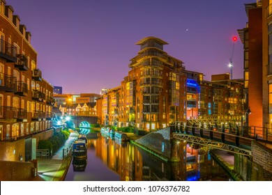 Night view of brick buildings alongside a water channel in the central Birmingham, England
