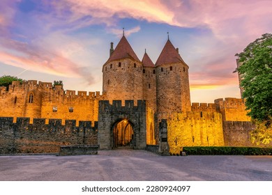 Night view of Carcassone medieval city in France against dramatic sunset sky 