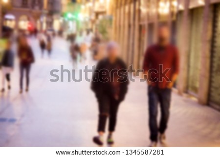 Night view of the city and illuminated the streets with pedestrians, nightlife. Strong blur, anonymous people on the streets of Europe