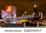 Night view of Cleveland cityscape at night with Cleveland sign and illuminated buildings in the background