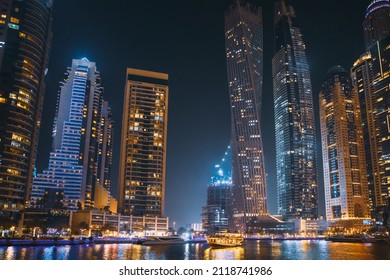 Night View Of Dubai Marina Towers. Night Walk On Tourist Boat, Sightseeing Boat Sailing On Dubai Marina Is District In Dubai, United Arab Emirates. Nighttime. Holidays In United Arab Emirates