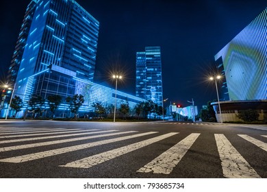 Night View Of Empty Road With Zebra Crossing And Buildings