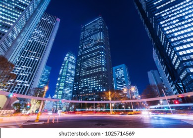 Night view of the intersection of Nishi-Shinjuku. Many cars run through the road between high-rise buildings. Shinjuku, Tokyo, Japan.