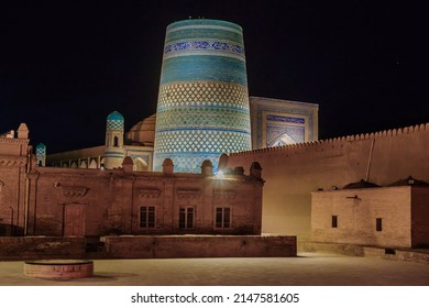 Night View Of Khiva, Uzbekistan. Blue Minaret Of Kalta-Minor Is In Center. Foreground (in Shade, Left To Right): Muhammad-Rakhim Madrasah, Kohna-Ark Palace, Small Building Of Zindan