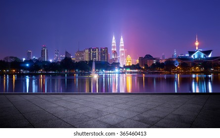 Night View Of Kuala Lumpur City With Stunning Reflection In Water And Empty Concrete Square Floor