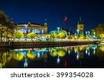 night view of the main train station in the swiss city zurich reflecting on surface of the limmat river
