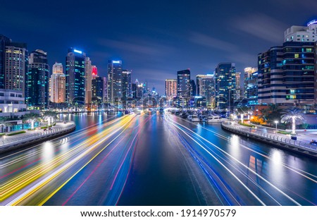 Night view on Dubai Marina skyscrapers, cruise boats and promenade in this luxury city, Dubai, United Arab Emirates