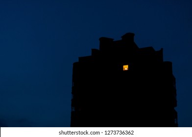 Night View On Old Residential Building Where The Light In On Only In One Room On The Highest Floor