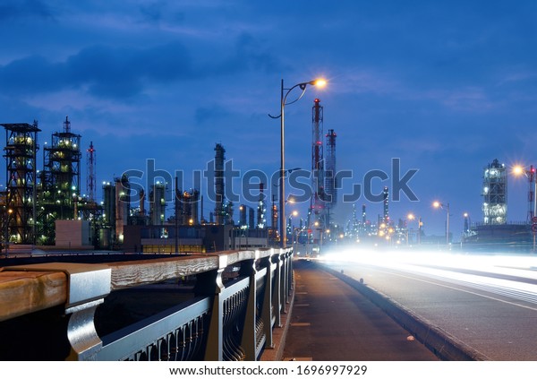 Night view of the pipelines & chimneys of\
petrochemical factories in Linyuan Industrial Estate at the end of\
Shuang Yuan Bridge with light trails of cars glowing at blue dusk\
in Kaohsiung City, Taiwan