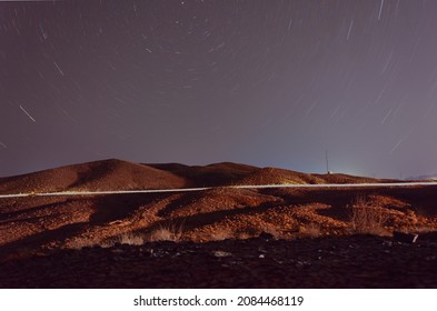 Night View From Plants And Hills In Desert With Light And Star Trails And North Star At Frame In Iran