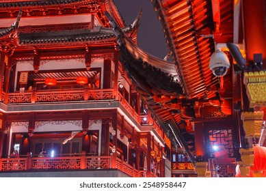 Night view of Shanghai's old town with red and gold buildings, ornate carvings, and upturned eaves, showcasing historical Chinese design. - Powered by Shutterstock