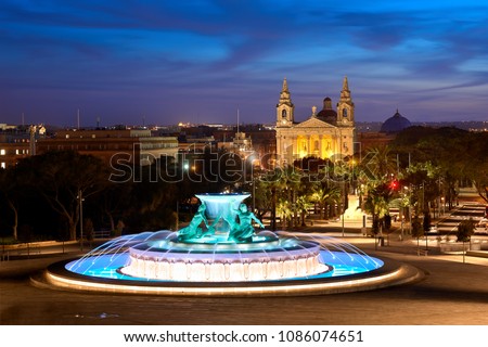 Night view at the Triton Fountain near the city gates of Valletta, Malta