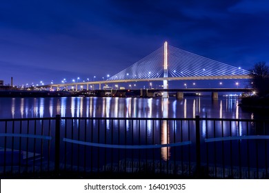 Night view of the Veterans' Glass City Skyway bridge in Toledo Ohio.  The bridges center pylon is lit up with LED lighting and the stainless steel cables are lit with floodlights.