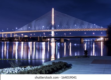 Night view of the Veterans' Glass City Skyway bridge in Toledo Ohio.  The bridges center pylon is lit up with LED lighting and the stainless steel cables are lit with floodlights.