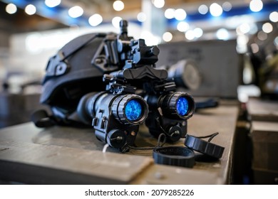 Night vision goggles on military helmet, closeup detail to blue reflective lenses