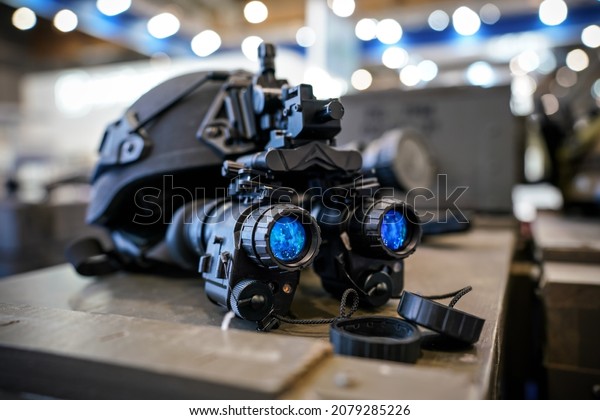 Night vision goggles on military\
helmet, closeup detail to blue reflective\
lenses