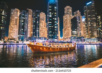 Night Walk On Tourist Boat, Sightseeing Boat Sailing On Dubai Marina. Night View Of Dubai Marina Towers Is District in Dubai, United Arab Emirates. Nighttime. Holidays In United Arab Emirates