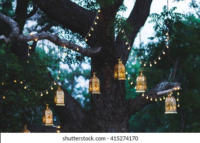 Night wedding ceremony with a lot of candles and vintage lamps on big tree - Shutterstock ID 415274170