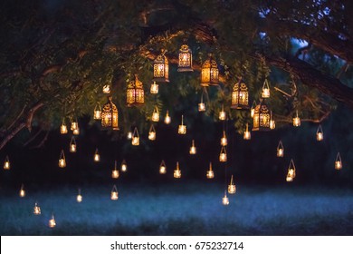 Night wedding ceremony with a lot of vintage lamps and candles on big tree - Powered by Shutterstock