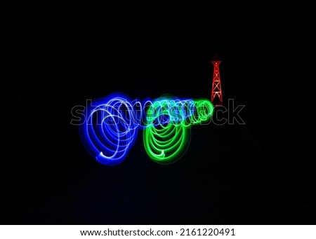 Night zoom photo effect with blue red green colored bursts that look like deliberately blurred streamers, motion effect, speed simulation and in the background a metallic red pole