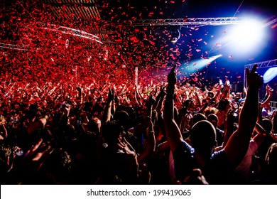 Nightclub party clubbers with hands in air and red confetti - Shutterstock ID 199419065