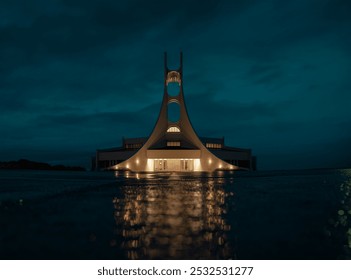 A night-lit, triangular building with circular openings reflects on water, set against a moody sky with glowing central lights. - Powered by Shutterstock