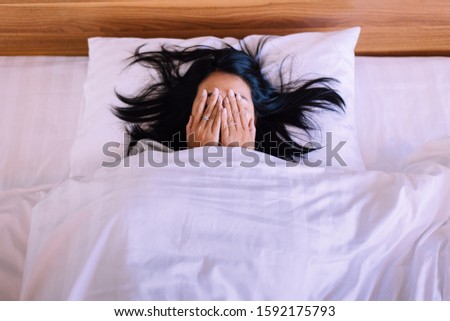 Nightmare or bad dream,Asian woman with scared and panic while lying down under the blanket in bedroom