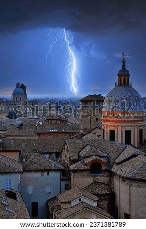 Nighttime aerial view of the city of Reggio Emilia during a thunderstorm with lightning and lightning seen from the bell tower of the church of San Prospero. Emilia Romagna, Italy