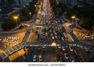 A nighttime aerial view of an intersection during the evening rush hour is filled with vehicles - Powered by Shutterstock