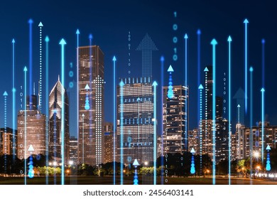 Nighttime cityscape with digital hologram of rising arrows and binary code, technology and business concept with skyscrapers on urban background. Double exposure