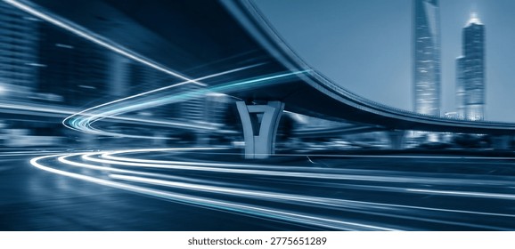 A nighttime cityscape showcasing dynamic light trails from vehicles passing under a bridge, contrasted against a blue-toned urban skyline.