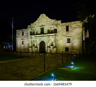 Nighttime Frontal Shot Of Famous Alamo Mission In San Antonio, Texas. Illuminated Facade Of Historic Building. Dark Night, No People Visible.