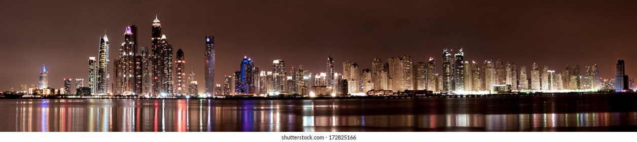 A nighttime  panoramic stitch of images looking from the Palm Jumeriah in Dubai, UAE across the Arabian Gulf at the Jumeriah Beach Residences and Dubai Marina