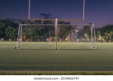 Nighttime photos of an amateur football match in a local stadium. Players are in action under bright stadium lights, capturing the dynamic energy and intensity of the game. - Powered by Shutterstock