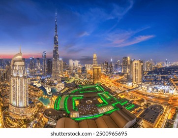 Nighttime view of Dubai's dazzling skyline with city lights twinkling, featuring the iconic Burj Khalifa, Dubai Mall, and the mesmerizing Dancing Fountain display - Powered by Shutterstock