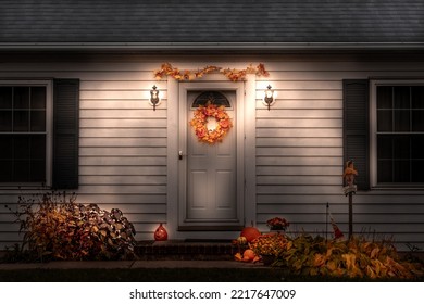 Nighttime White Home Exterior Beautifully Decorated In The Fall With Autumn Decor For Thanksgiving And Halloween

