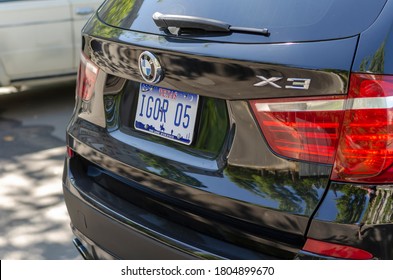 Nikolaev, Ukraine - August 26, 2020: Rear of BMW X3 car in the parking lot. Black SUV with special Texas license plates. Russian name Igor on the license plate.