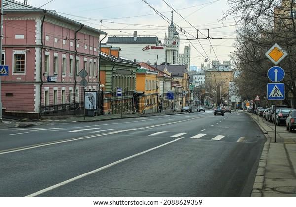 Nikoloyamskaya Street in Moscow. The road with a\
crosswalk and signs. Old buildings and the office of the real\
estate agency Miel. The gray urban landscape. Russia, Moscow, March\
20, 2011