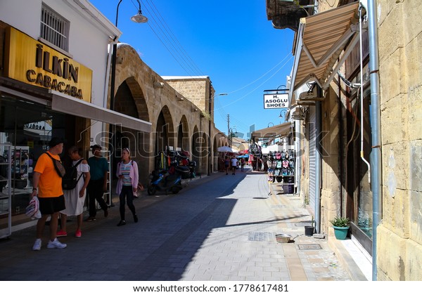 Nikosia, Northern Cyprus -\
September 23, 2019: Tourism scene with visitors and small shops in\
a narrow street in the historical center of Nikosia, Northern\
Cyprus. 
