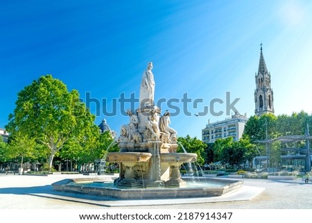 Nimes, city in Southern France, Gard, Occitanie, Pradier fountain and church on summer day