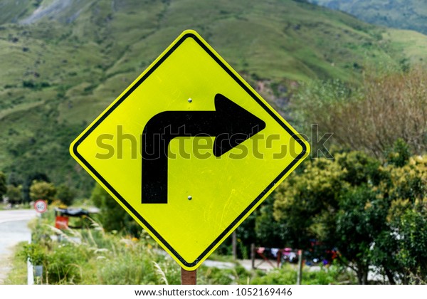 ninety
degree curve road sign to the right made with yellow and black
reflective paint. back you can see the
landscape