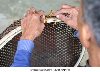 Ninh Binh, Vietnam - 25 Oct 2021: Vietnamese craftsman weave baskets with natural materials: rattan and bamboo