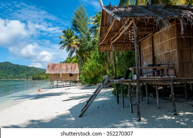 Nipa bamboo Huts at the White Sand beach with palm trees in Raja Ampat, Papua New Guinea, Indonesia