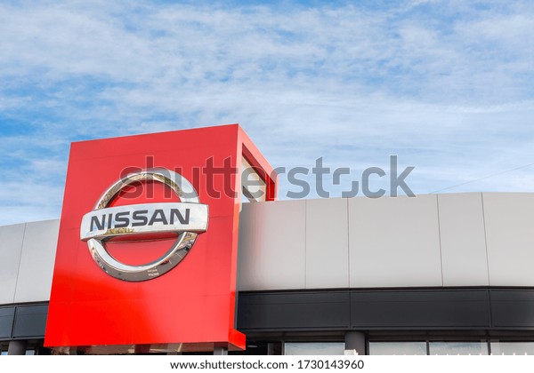 Nissan brand logo on bright blue sky background\
located on its dealer office building in Lyon, France - February\
23, 2020