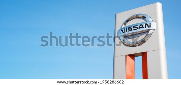 Nissan car manufacturer Japanese\
company logo, clear blue sky background outside. Banner, copy\
space, blank space for your text. Smolensk, Russia\
04.18.2021