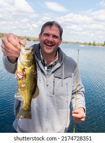 NISSWA, MINNESOTA USA - MAY 15, 2021: Happy Fisherman Holding His Giant Rock Bass Fish Close To The Camera Lens To Make It Larger.