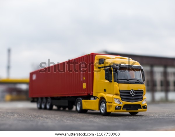 NITRA, SLOVAKIA - DECEMBER 26 2017: Scale model\
Mercedes-Benz Actros with container trailer. Truck with trailer on\
the road. Yellow truck.