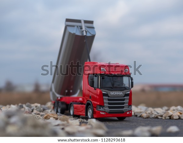 NITRA, SLOVAKIA - DECEMBER 27 2017:\
Red Scania CR 20 with gray dumper. Red truck with trailer. Scania\
truck on the road. Scale model from Herpa model,\
1:87.
