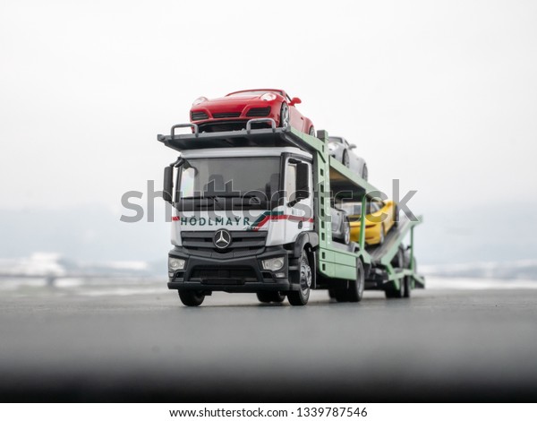 NITRA,\
SLOVAKIA - MARCH 15 2019: Mercedes-Benz Actros with car transporter\
trailer. Scale model 1:87 from Herpa. Truck with car transporter\
trailer. Porsche cars on car transporter\
trailer.