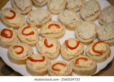 Niva cheese and garlic canapés with red pepper.